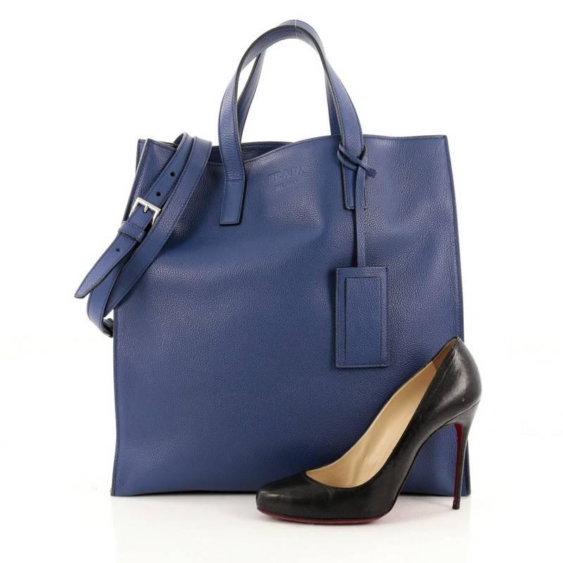 This authentic Prada Convertible Tote Vitello Daino Large is perfect for your everyday casual looks. Crafted from bluette blue vitello daino leather, this satchel features dual flat handles, detachable shoulder strap, embossed Prada logo at its