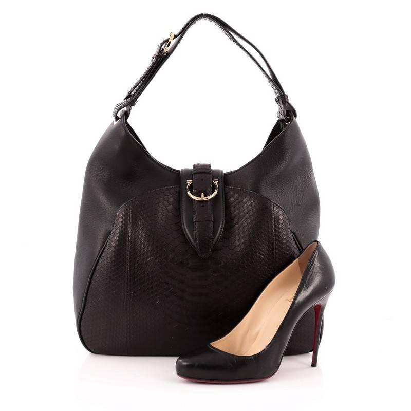 This authentic Salvatore Ferragamo Buckle Hobo Leather and Python Large is an eye-catching and luxurious piece made to stand-out amongst the crowd. Crafted from black leather and python, this hobo features a adjustable single looped python shoulder