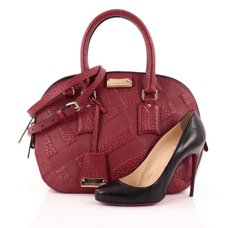 This authentic Burberry Orchard Bag Embossed Check Leather Small has an elegant and simplistic design with a compact silhouette that is ideal for everyday use. Crafted from red embossed check leather, this vintage-inspired bag features dual-rolled