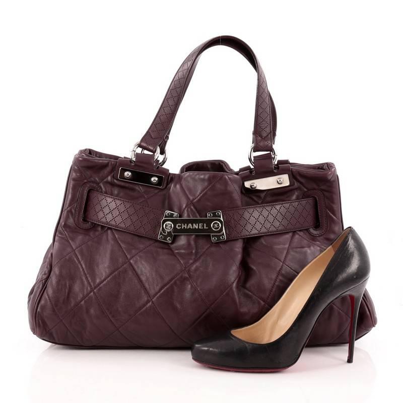This authentic Chanel Belted Tote Quilted Leather Large is the perfect daily carry-all bag for any serious fashionista. Crafted from purple quilted leather, this functional tote features belted leather straps with an engraved silver name plate that