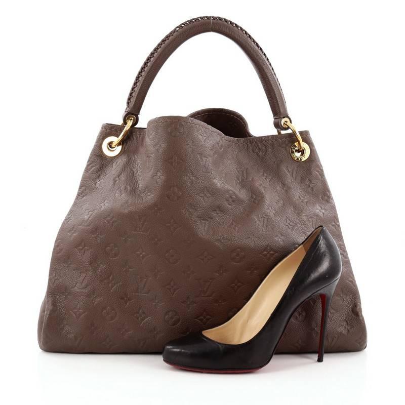 This authentic Louis Vuitton Artsy Handbag Monogram Empreinte Leather MM is as elegant as it is sturdy. Crafted from ombre brown monogram embossed empreinte leather, this luxurious and refined hobo features a single looped braided top handle with