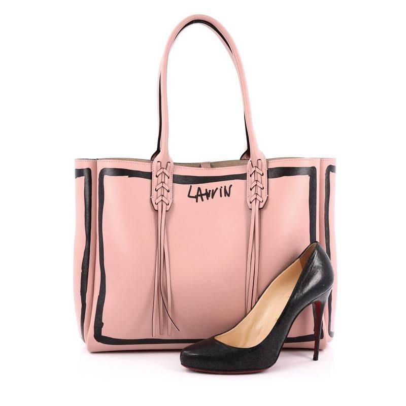 This authentic Lanvin Nela Shopper Tote Printed Leather Small is a sought-after tote perfect for your everyday use. Crafted from pink leather with a painted effect, this chic tote features dual-rolled leather shoulder straps with woven fringe,