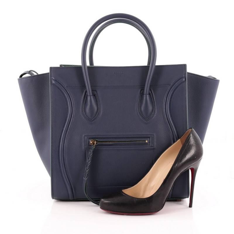 This authentic Celine Phantom Handbag Grainy Leather Large is one of the most sought-after bags beloved by fashionistas. Crafted from navy blue grainy leather, this minimalist tote features dual-rolled handles, an exterior front pocket with braided