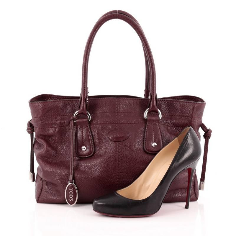 This authentic Tod's Classic D-Bag Tote Leather Medium is the perfect accessory for everyday and work excursions. Constructed in burgundy leather, this no-fuss, easy-to-carry tote features dual rolled slim handles, drawstring pulls at sides,
