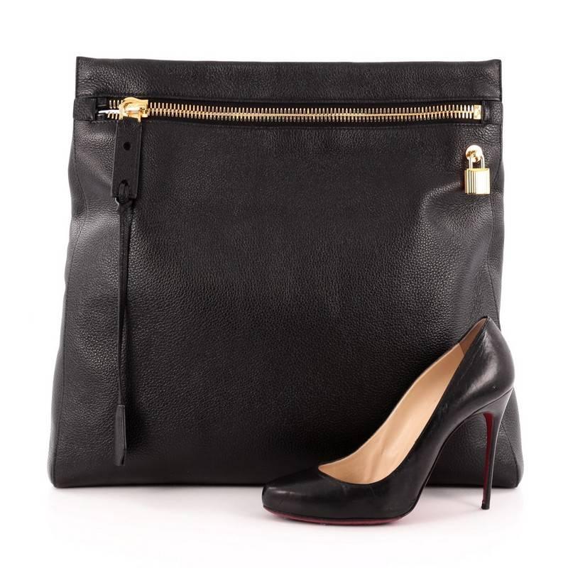 This authentic Tom Ford Alix Clutch Leather Large showcases a minimalist and functional accessory perfect for the modern woman. Crafted from black grainy leather, this impossibly chic accessory features a cutout top handle, front and back zip