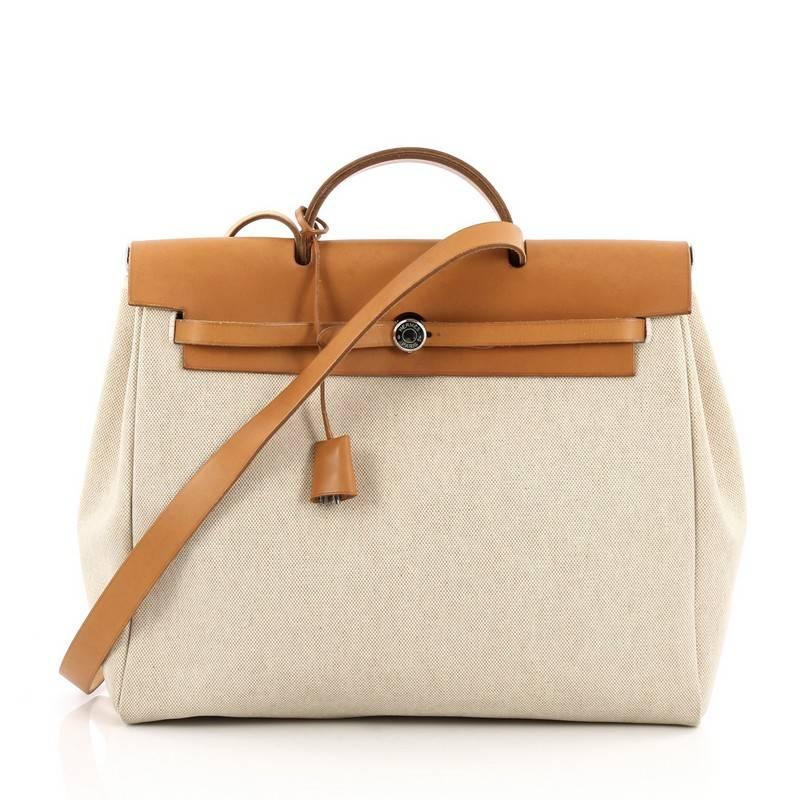 This authentic Hermes Herbag Toile and Leather MM is a fabulously functional, lightweight tote made for everyday excursions. Constructed from natural beige canvas and vache hunter leather, this versatile tote features a flat leather top handle,