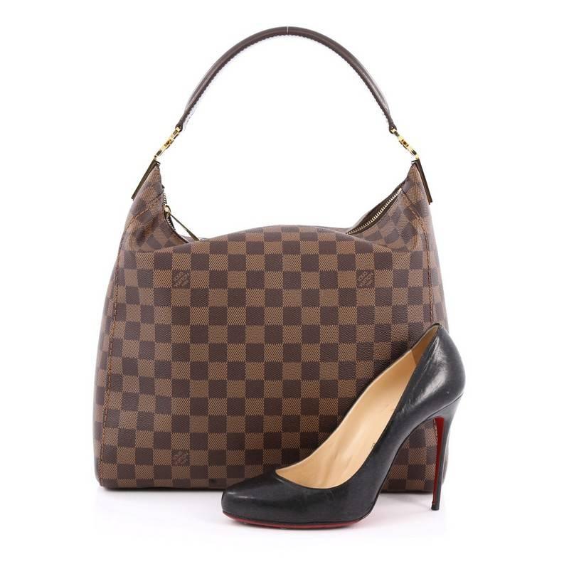 This authentic Louis Vuitton Portobello Handbag Damier PM is a modern and easy-to-carry city hobo made for everyday excursions. Crafted in signature damier ebene coated canvas, this beauty features a simple silhouette, single looped leather handle,