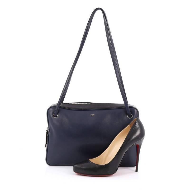 This authentic Celine Bicolor Side Lock Bag Leather Medium presented in the brand's 2013 Collection is perfect for the modern fashionista. Crafted from bicolor navy blue and black leather, this chic bag featured dual fat shoulder straps, exterior