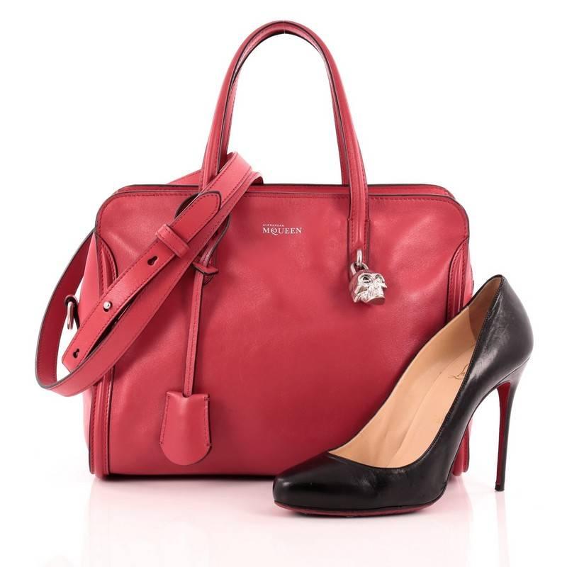 This authentic Alexander McQueen Padlock Zip Around Tote Leather Small is a youthful and vibrant accessory made for every fashionista. Crafted from stunning red leather, this functional tote features dual-rolled handles, leather shoulder strap,