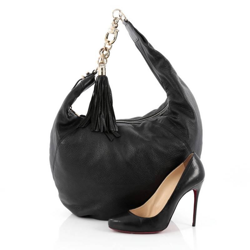 This authentic Gucci Sienna Hobo Leather Medium is a simple, stylish hobo made for everyday use. Crafted from black leather, this hobo features a horsebit hook, metal chain with leather tassel accent and gold-tone hardware accents. Its zip closure