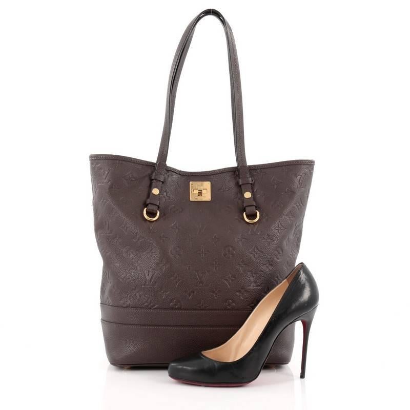 This authentic Louis Vuitton Citadine Handbag Monogram Empreinte Leather PM is sophisticated and elegant in design. Crafted in brown embossed monogram empreinte leather, this classic tote features slim handles, protective base studs and gold-tone