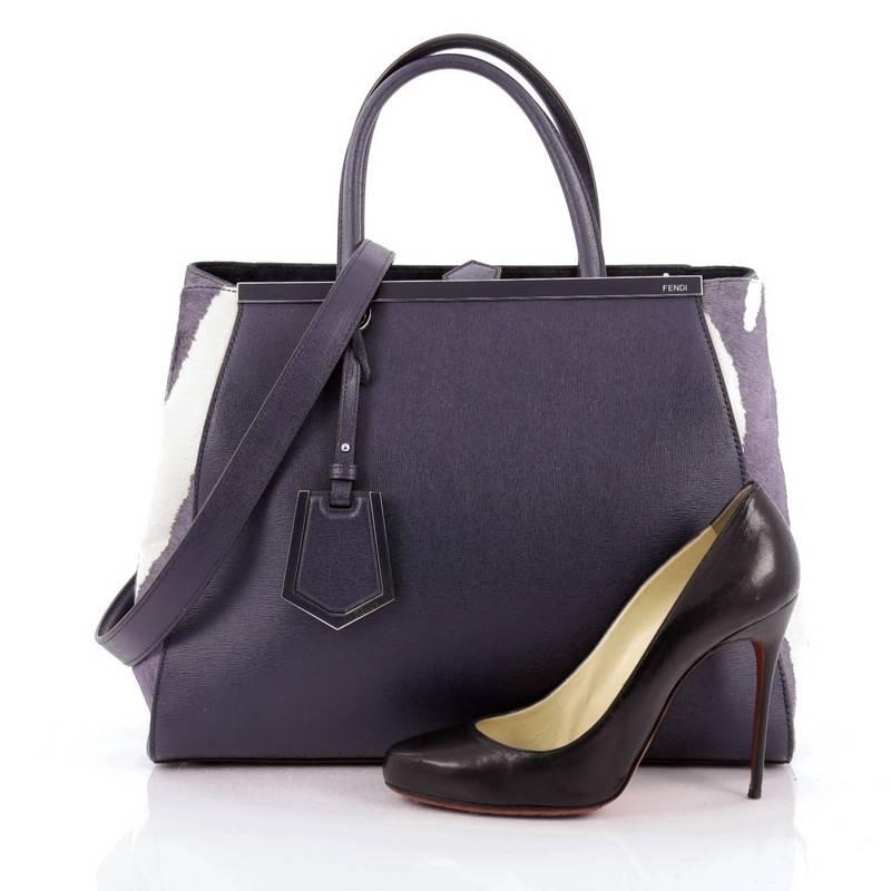This authentic Fendi 2Jours Handbag Pony Hair and Leather Medium is impeccably stylish and structured design with a luxurious twist. Finely crafted in blue leather with purple and white genuine pony hair sides, this popular tote features a shining