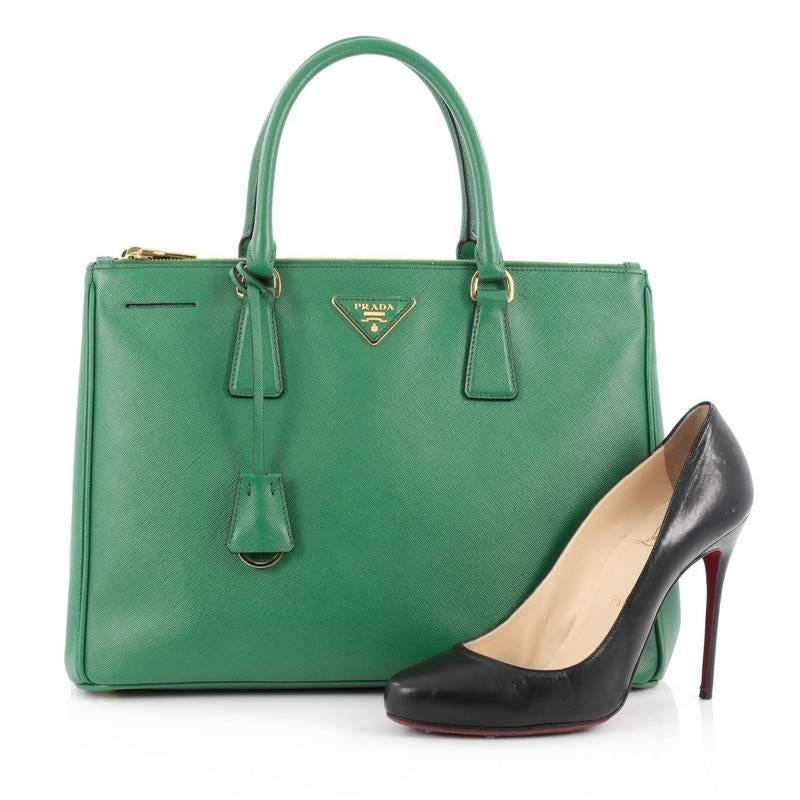 This authentic Prada Double Zip Lux Tote Saffiano Leather Medium is the perfect bag to complete any outfit. Crafted from green saffiano leather, this boxy tote features side snap buttons, raised Prada logo, dual-rolled leather handles and gold-tone