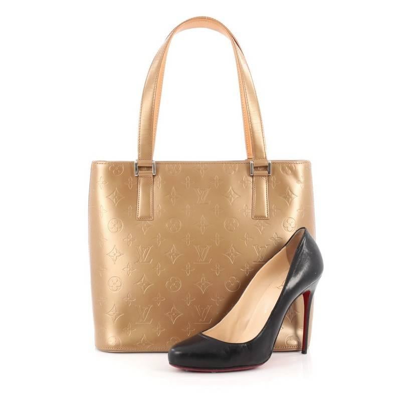 This authentic Louis Vuitton Mat Stockton Handbag Monogram Vernis is a stylish and functional bag made for everyday use or weekend getaways. Crafted from gold monogram vernis leather, this tote features dual flat handles, vachetta leather trims, and