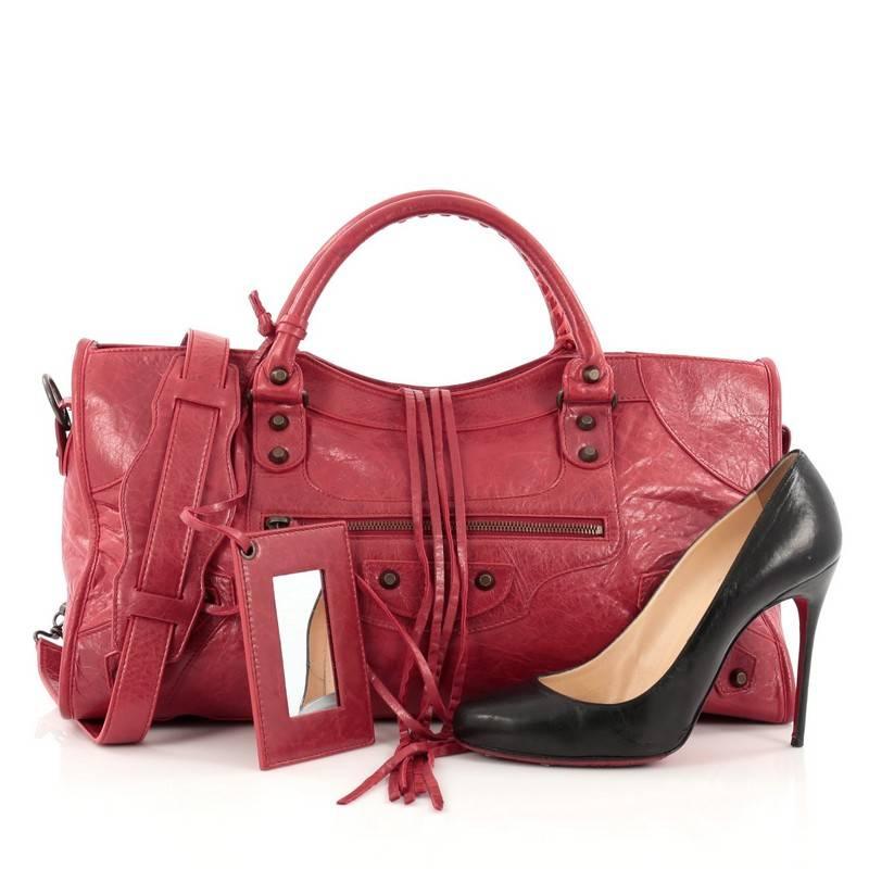 This authentic Balenciaga Part Time Classic Studs Handbag Leather is a perfect companion for daily excursions. Designed in red leather, this stylish bag features dual braided handles, front zipped pocket with tassels, iconic brass Balenciaga classic