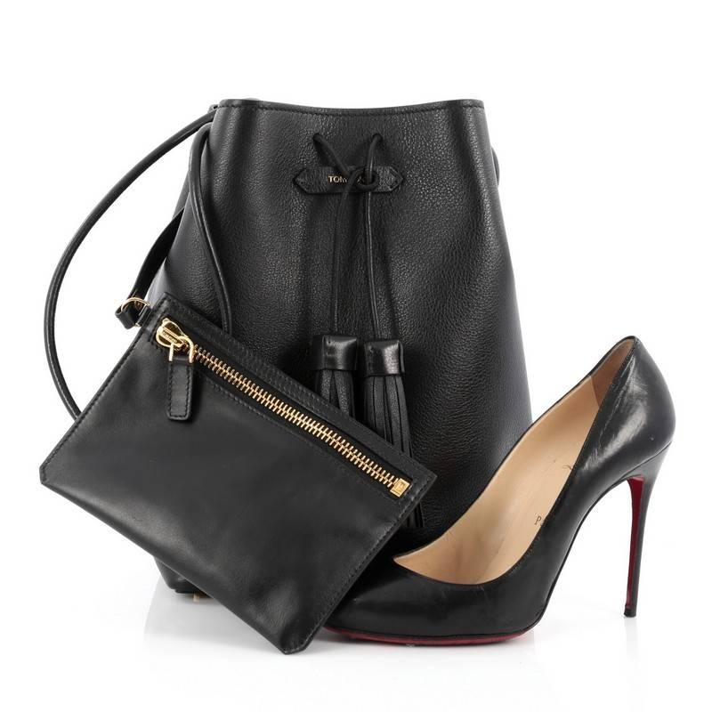 This authentic Tom Ford Tassel Bucket Bag Leather Medium is a chic bucket bag perfect for on-the-go moments. Crafted from black leather, this sleek, understated bag features rolled crossbody strap, logo applique at center, tassel drawstring top