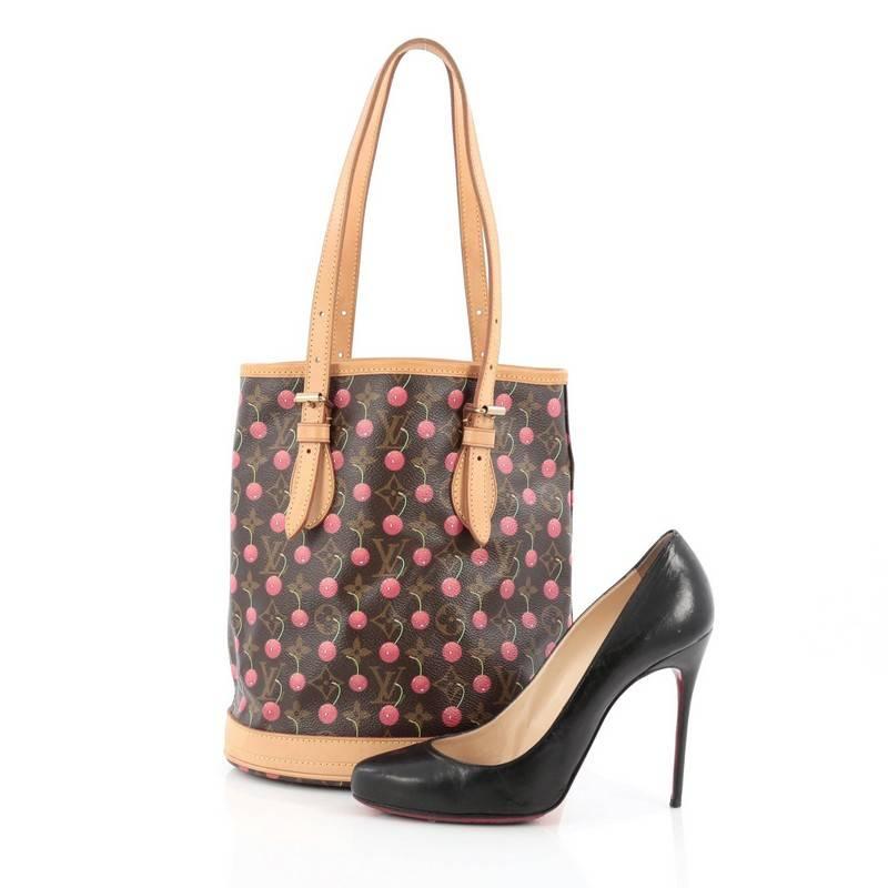 This authentic Louis Vuitton Bucket Bag Limited Edition Cerises designed by famed Japanese artist Takashi Murakami puts a fun twist to the classic bucket bag. Crafted from brown monogram coated canvas adorned with bright cheerful cherries, this