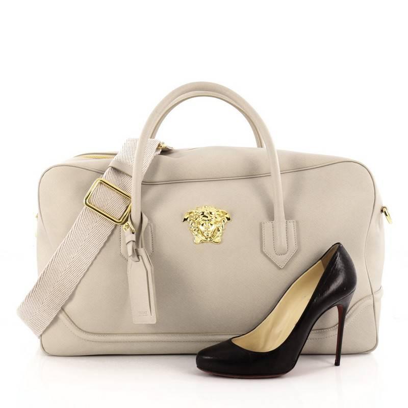 This authentic Versace Palazzo Briefcase Saffiano Leather Large is a simple and luxurious bag that's perfect for your everyday looks. Crafted from beige saffiano leather, this bag features dual-rolled leather handles, detachable shoulder strap, the