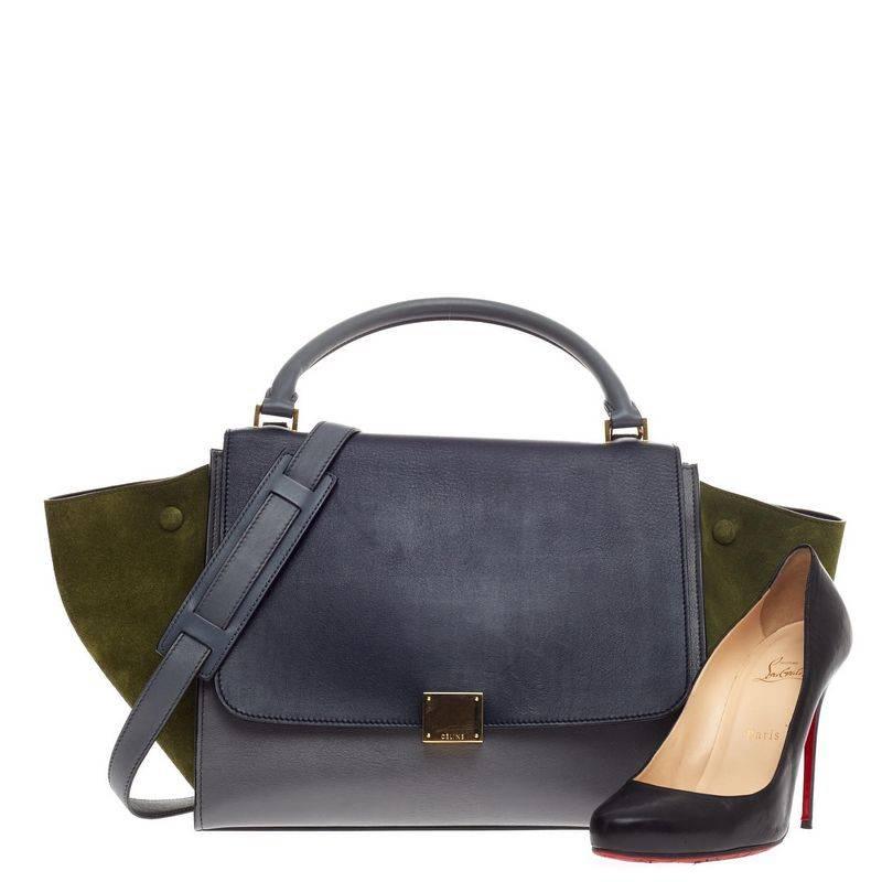This authentic Celine Trapeze Tricolor Leather Medium presented in the brand's 2013 Collection is a modern classic, featuring a cool palette of navy blue and blue gray leather body with a striking olive suede wings. With its subdued color palette,