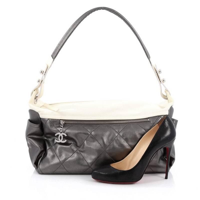 Este auténtico Chanel Biarritz Hobo acolchado de lona revestida grande, presentado en la Colección de Viaje París Biarritz 2007 de la marca, tiene un diseño sencillo y sofisticado que puede dar glamour a tu look informal. Confeccionado en lona