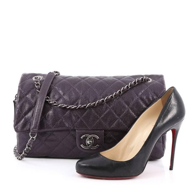 This authentic Chanel Easy Flap Bag Quilted Caviar Jumbo exudes a classic yet easy style made for the modern woman. Crafted from purple caviar leather with Chanel's signature diamond quilting design, this elegant flap features dual woven-in leather
