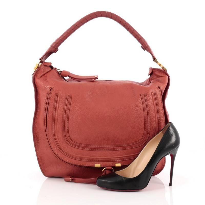 This authentic Chloe Marcie Hobo Leather Large showcases the brand's popular horseshoe design in a classic hobo silhouette. Constructed from red leather, this functional yet stylish hobo bag features a slouchy, easy-to-carry silhouette, wrapped