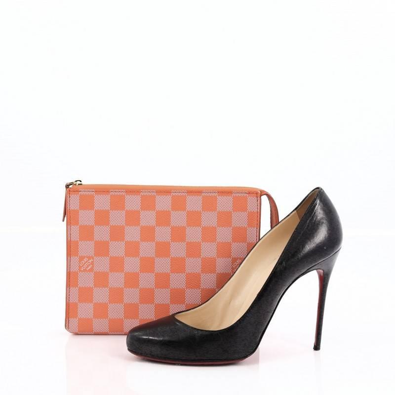 This authentic Louis Vuitton Element Clutch Damier Couleurs launched in Cruise 2014 collection is playful and bright in design perfect for summer season. Crafted in orange damier, this clutch features a simple silhouette with zip closure and