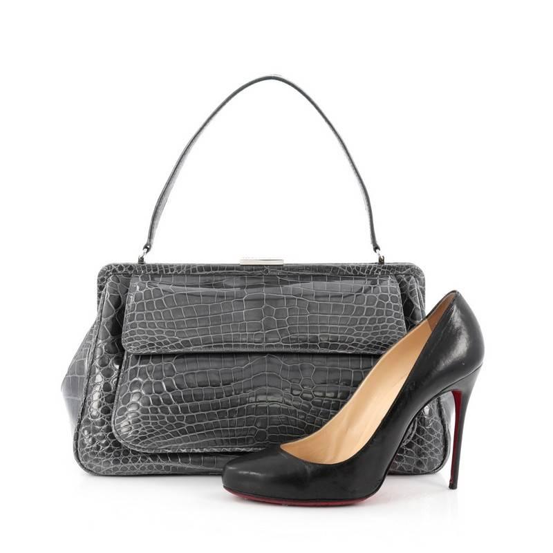 This authentic Tiffany & Co. Laurelton Handbag Crocodile is a chic and sophisticated bag perfect for everyday looks and night outs. Crafted from genuine gray crocodile skin, this luxurious, exotic bag features a single flat handle, exterior pocket