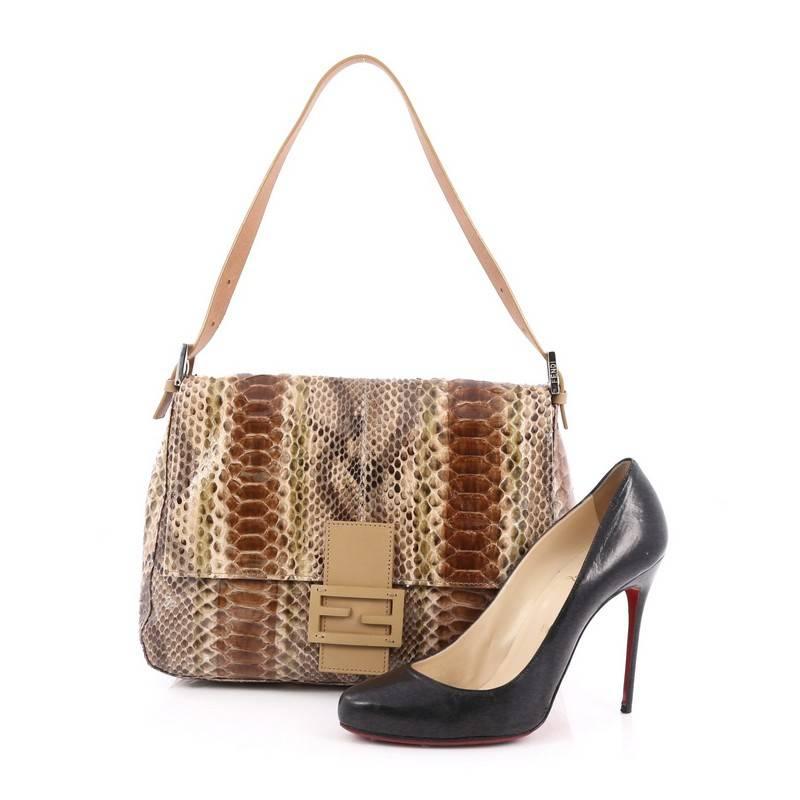 This authentic Fendi Mama Forever Handbag Python is a classic stylish bag with a twist of perfect for daily excursions. Crafted from genuine brown multicolor python skin, this flap bag features a flat leather strap, stylized Fendi hardware