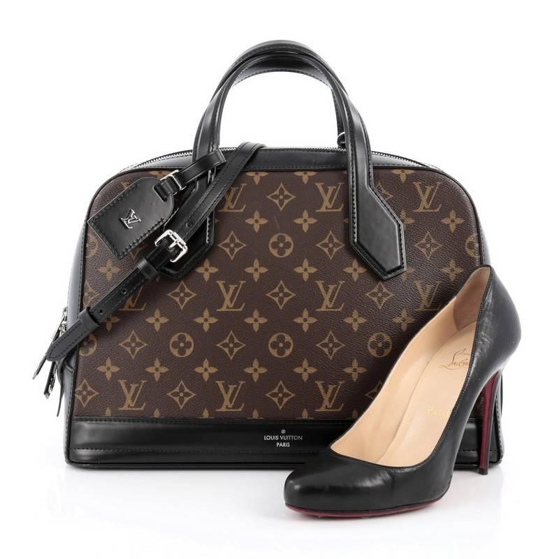 This authentic Louis Vuitton Dora Handbag Monogram Canvas and Calf Leather MM presented in the brand's Pre-Fall 2015 Collection is inspired by Gaston Vuitton's iconic squire travel bag. Crafted from brown monogram printed canvas and black leather,