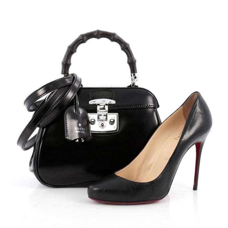This authentic Gucci Lady Lock Bamboo Top Handle Bag Leather Mini is perfect for day to night. Crafted in smooth black leather, this bag features single loop bamboo handle, lady lock closure, leather clochette with keys and silver-tone hardware