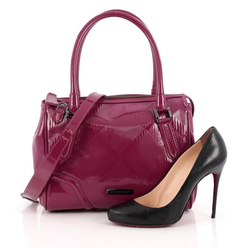 This authentic Burberry Anford Convertible Bowling Bag Embossed Patent Medium is a chic accessory for any fashionista. Crafted from raspberry pink check embossed patent leather, this stylish bag features dual-rolled leather handles, removable