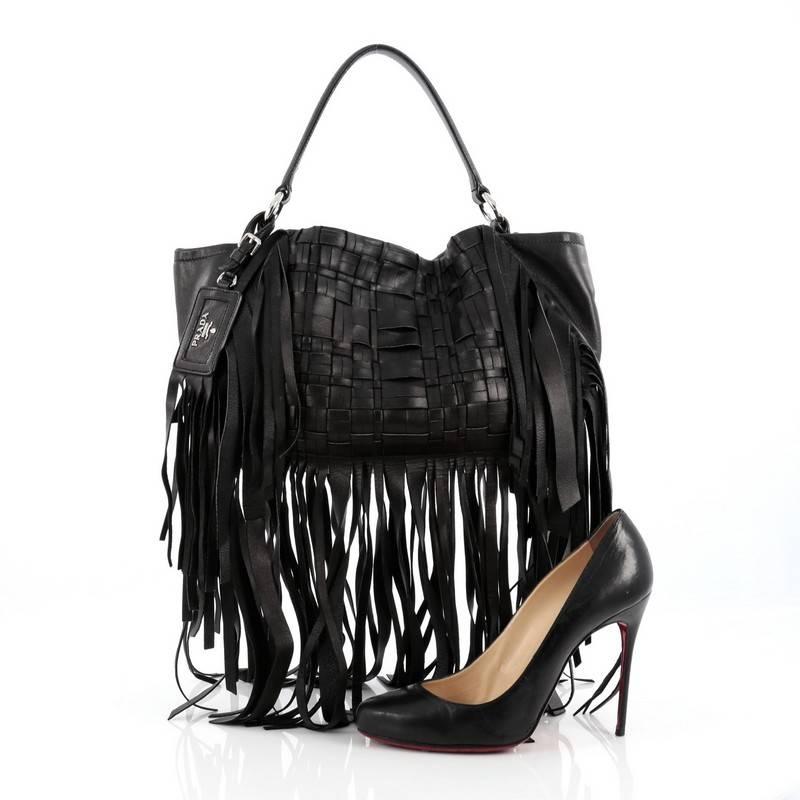 This authentic Prada Convertible Fringe Shoulder Bag Woven Nappa Leather Medium balances a traditional boho design with a chic and sleek twist perfect for modern fashionistas. Crafted in nero black woven nappa leather, this stylish tote features
