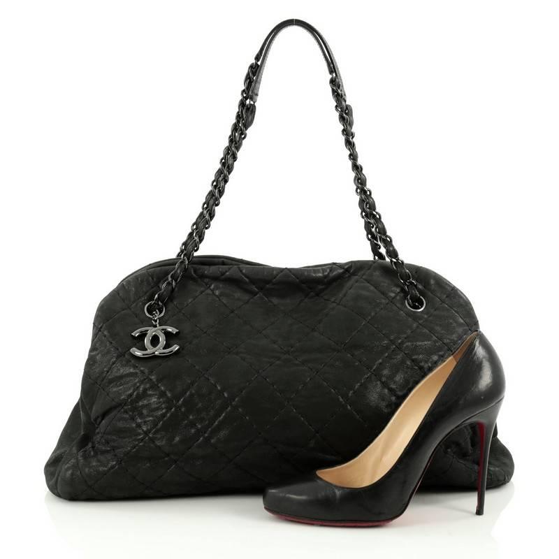 This authentic Chanel Just Mademoiselle Handbag Quilted Iridescent Leather Maxi showcases a sleek style that complements any look. Crafted from black iridescent leather in Chanel's iconic diamond quilted pattern, this oversized tote features a