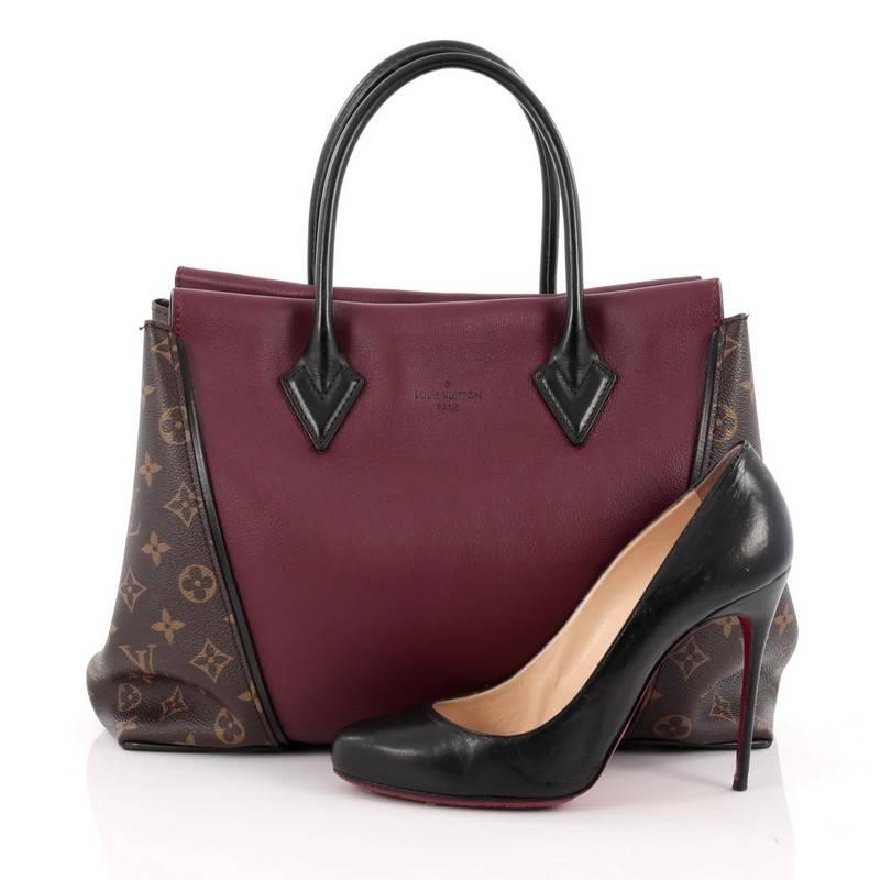 This authentic Louis Vuitton W Tote Monogram Canvas and Leather PM presented in the brand's 2013 Collection is a collector’s dream. Crafted in brown plum and black leather and monogram coated canvas sides, this luxurious and elegant tote features