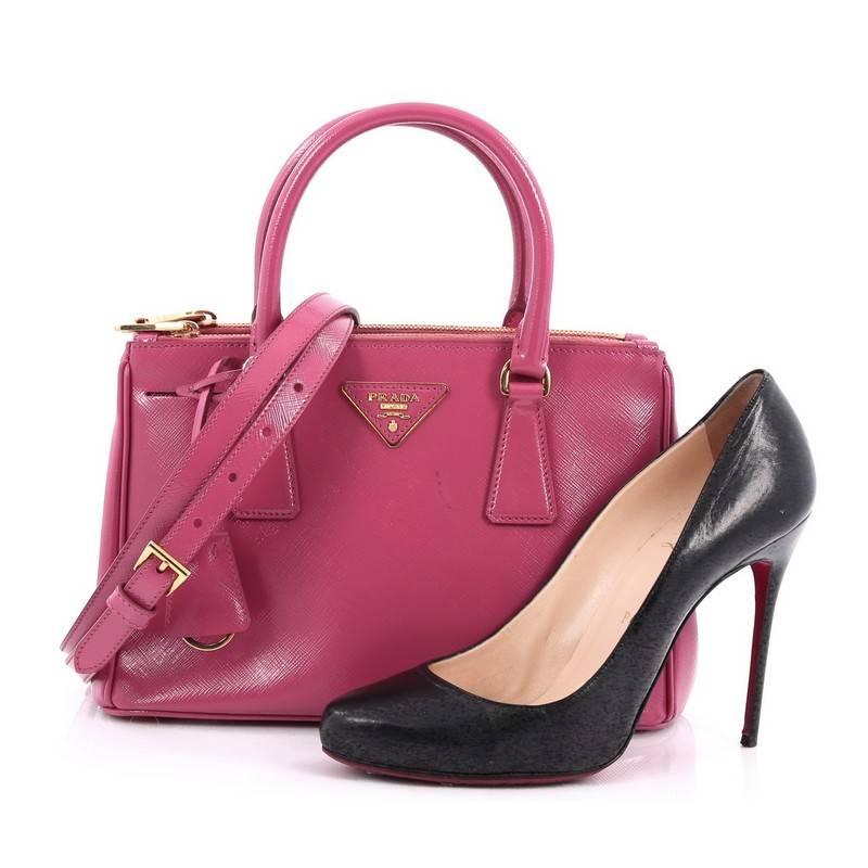 This authentic Prada Double Zip Lux Tote Vernice Saffiano Leather Mini is the perfect bag to complete any outfit. Crafted from pink vernice saffiano leather, this boxy, petite tote features side snap buttons, raised Prada logo, dual-rolled leather