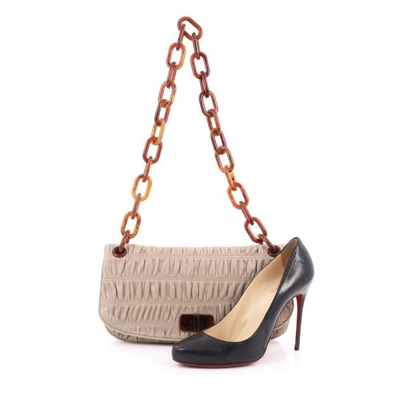 This authentic Prada Resin Chain Gaufre Flap Bag Leather Medium is the perfect bag for Prada lovers. Crafted from gray leather, this flap bag features a ruched sihouette, exterior rear flat pocket with magnetic snap closure, oversized resin chain
