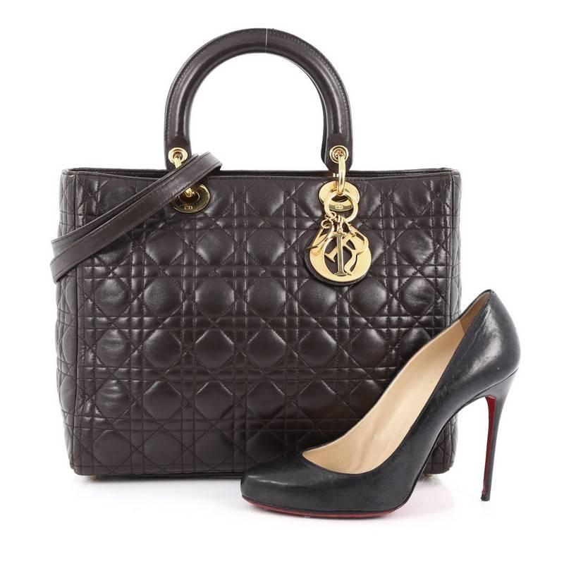 This authentic Christian Dior Lady Dior Handbag Cannage Quilt Lambskin Large is a classic staple that every fashionista needs in her wardrobe. Crafted from dark brown lambskin leather in Dior's iconic cannage quilting, this boxy bag features