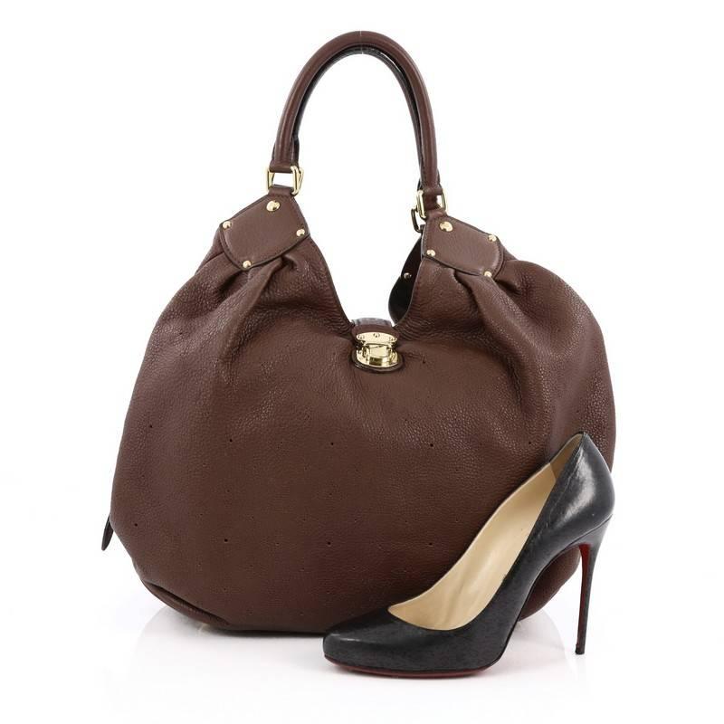 This authentic Louis Vuitton XL Hobo Mahina Leather is sleek and refined in design apt for the modern woman. Crafted from the brand's brown monogram perforated mahina leather, this oversized, feminine hobo features dual-rolled handles, buckle and