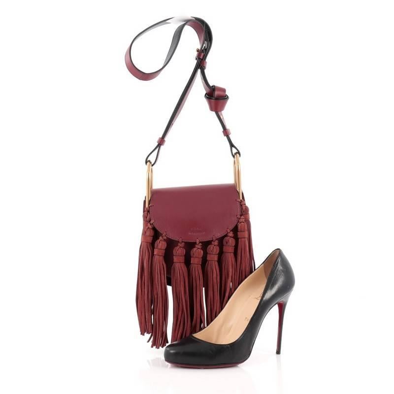 This authentic Chloe Hudson Fringe Tassel Handbag Leather Mini mixes casual-bohemian styling with luxurious edge made for the Chloe girl. Crafted from burgundy leather, this saddle-style, crossbody bag features adjustable long flat shoulder strap