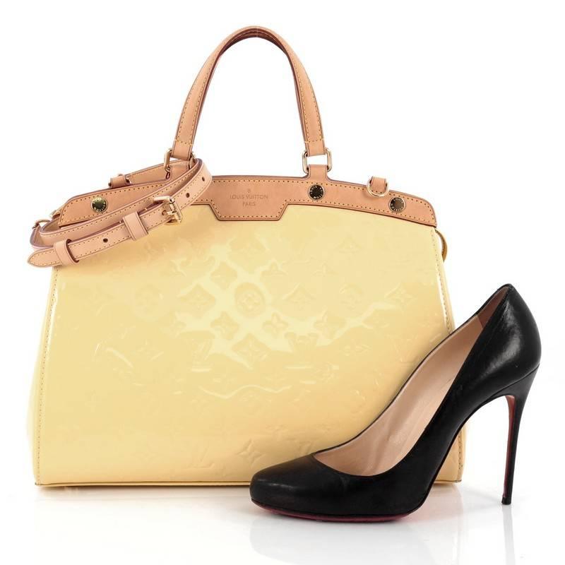 This authentic Louis Vuitton Brea Handbag Monogram Vernis MM is a staple for an everyday casual look. Crafted in canary yellow monogram vernis leather with cowhide leather trims, this structured yet feminine tote features dual flat handles,