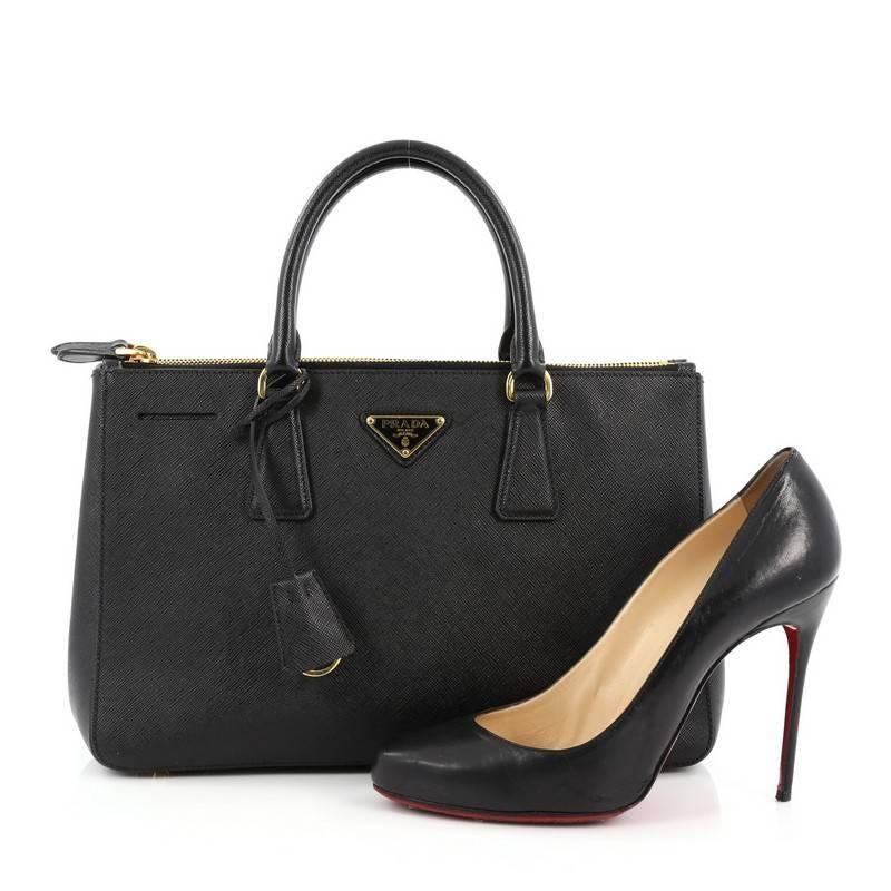This authentic Prada Double Zip Lux Tote Saffiano Leather Small is the perfect bag to complete any outfit. Crafted from nero black saffiano leather, this boxy tote features side snap buttons, raised Prada logo, dual-rolled leather handles,