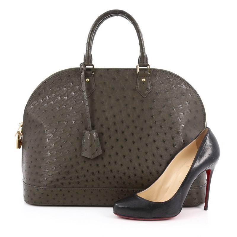 This authentic Louis Vuitton Alma Handbag Ostrich GM is a timeless piece made for anyone with impeccable taste. Crafted from genuine green ostrich skin, this dome-like bag features dual-rolled ostrich leather handles, protective base stud and