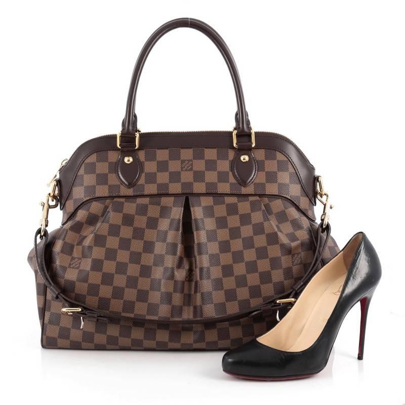 This authentic Louis Vuitton Trevi Handbag Damier GM inspired by the Trevi Fountain is a chic and versatile handle bag. Crafted from classic damier ebene coated canvas, this tote features dual-rolled handles, brown leather trims, subtle pleats in