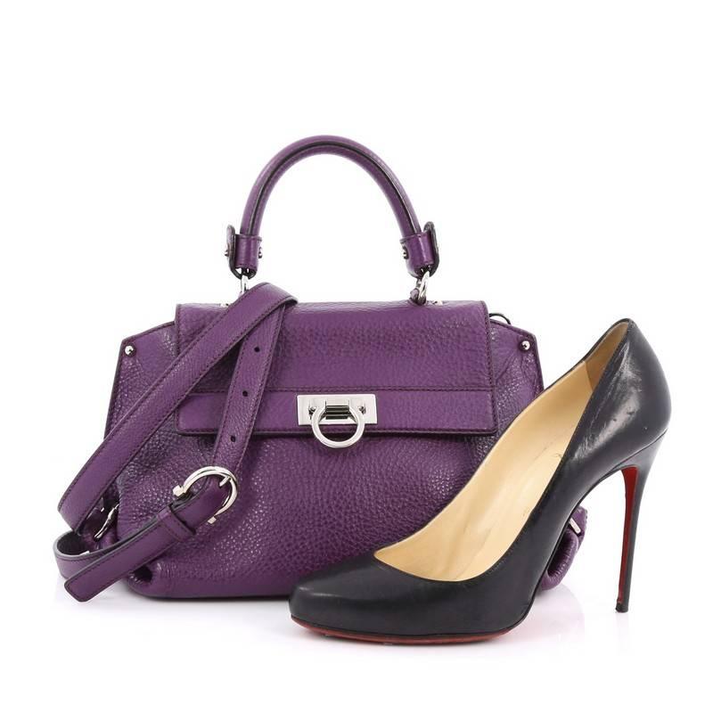 This authentic Salvatore Ferragamo Sofia Satchel Pebbled Leather Small is stylish and functional. Crafted in purple pebbled leather, this bag features a sturdy top handle with exterior back zip pocket, protective base studs and silver-tone hardware