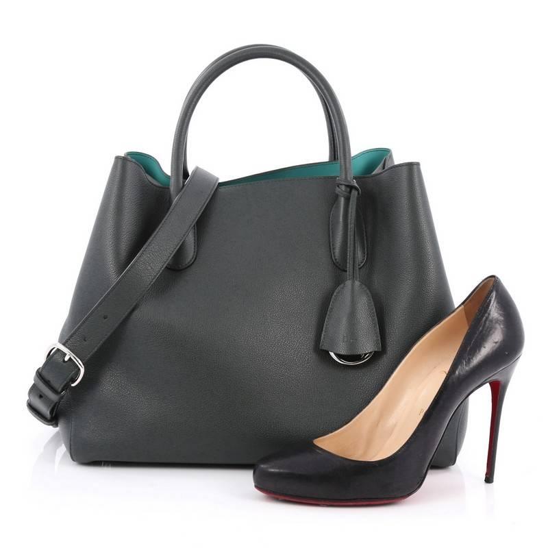 This authentic Christian Dior Open Bar Bag Leather Large takes inspiration from the brand's iconic Dior Bar jacket. Crafted in beautiful dark green leather, this impeccably chic tote features a clean and soft-structured design, dual-rolled handles,