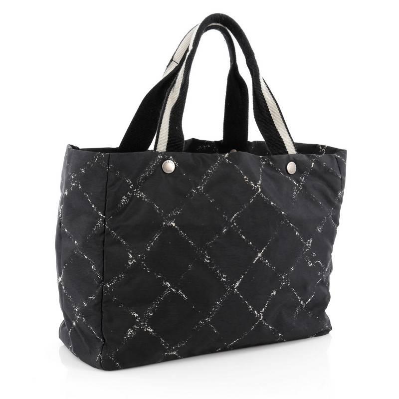 This authentic Chanel Travel Line Tote Printed Nylon Large showcases the brand's sporty style with everyday functionality perfect for any excursion. Crafted from black nylon with geometric print design, this lightweight tote features dual flat black