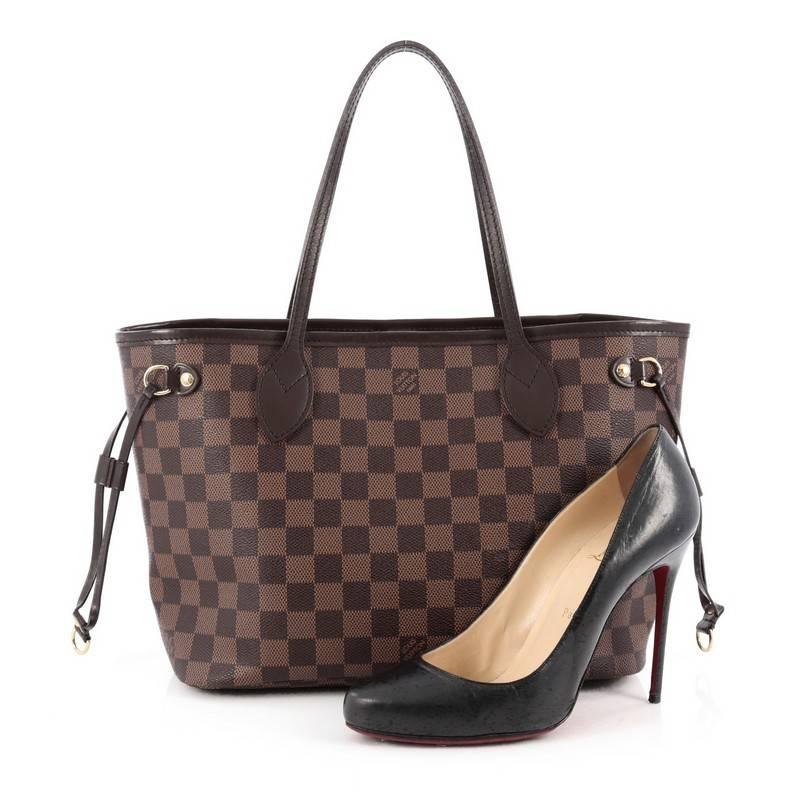 This authentic Louis Vuitton Neverfull NM Tote Damier PM is a popular and practical tote beloved by many. Constructed with Louis Vuitton's signature damier ebene coated canvas, this tote is spacious and structured without being bulky. The side laces