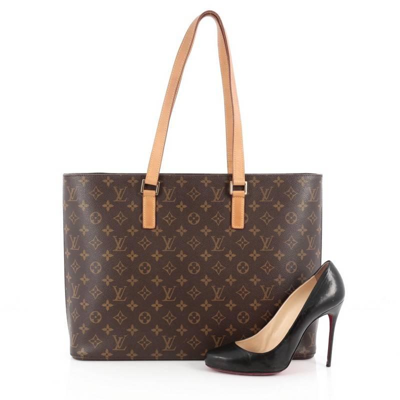 This authentic Louis Vuitton Luco Handbag Monogram Canvas is a classic tote that displays fashion and functionality all rolled into one. Crafted with the brand's iconic brown monogram coated canvas, this tote features dual flat leather handles, a