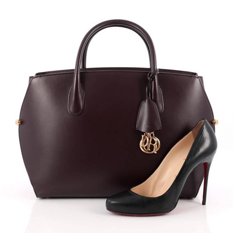 This authentic Christian Dior Bar Bag Leather Large takes inspiration from the brand's iconic Dior Bar jacket. Crafted in beautiful plum leather, this impeccably chic tote features a clean and soft-structured design, dual-rolled handles, gold-tone